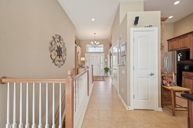 hall featuring light tile patterned floors, a chandelier, and recessed lighting