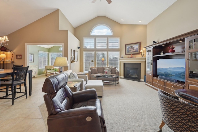 living area with light tile patterned floors, baseboards, a fireplace with flush hearth, ceiling fan, and high vaulted ceiling