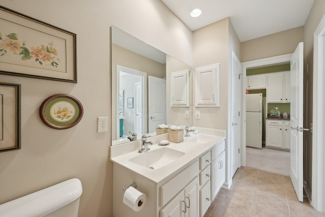 full bath featuring tile patterned flooring, a sink, toilet, and double vanity