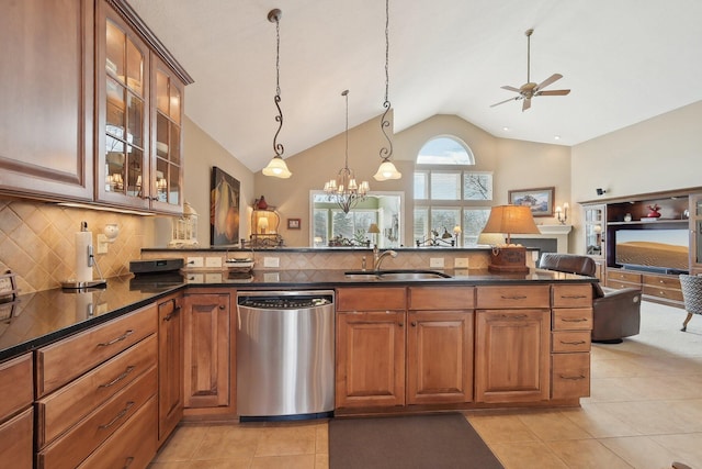 kitchen with open floor plan, stainless steel dishwasher, dark countertops, and a sink