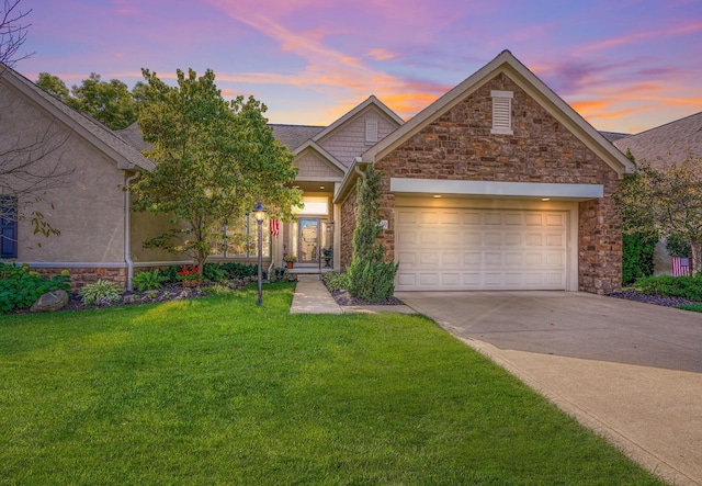 view of front of home with driveway, stone siding, an attached garage, and a lawn