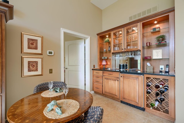 bar featuring light tile patterned floors, wine cooler, visible vents, and wet bar