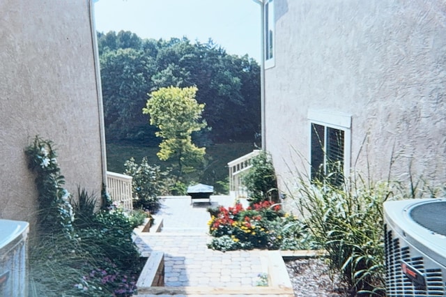 view of side of home featuring central air condition unit and stucco siding