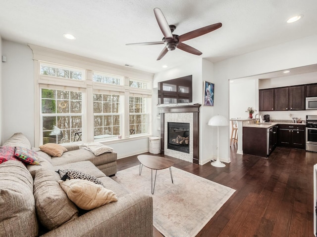 living area with a fireplace, dark wood-type flooring, and recessed lighting