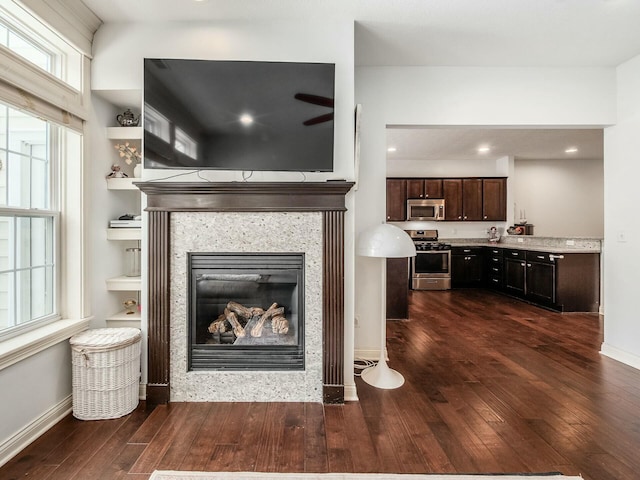 living room featuring recessed lighting, baseboards, dark wood finished floors, and a tile fireplace