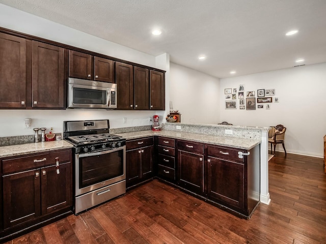 kitchen featuring appliances with stainless steel finishes, a peninsula, and light stone countertops