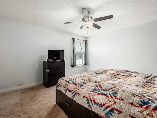 carpeted bedroom featuring a textured ceiling, ceiling fan, and baseboards