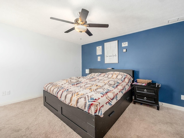 bedroom featuring a textured ceiling, baseboards, a ceiling fan, and light colored carpet