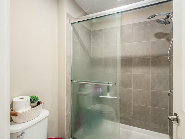 bathroom featuring a tile shower and toilet