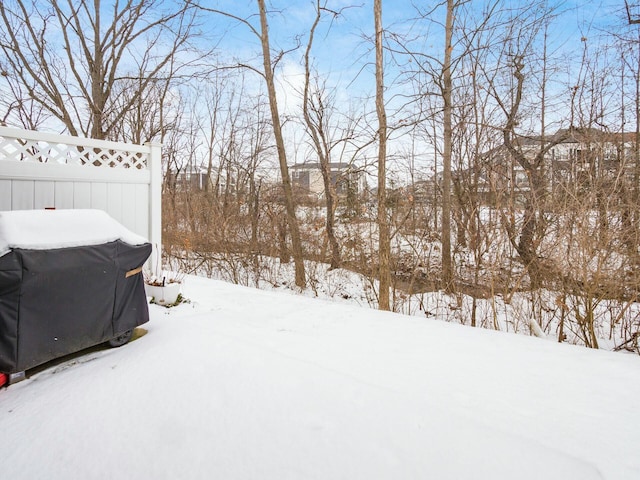 snowy yard featuring fence