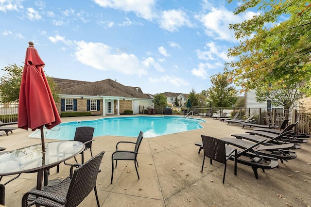 pool featuring fence and a patio