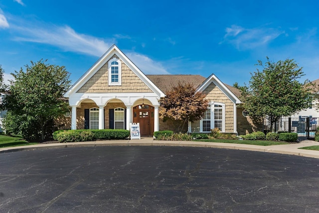 view of front of house featuring covered porch and fence