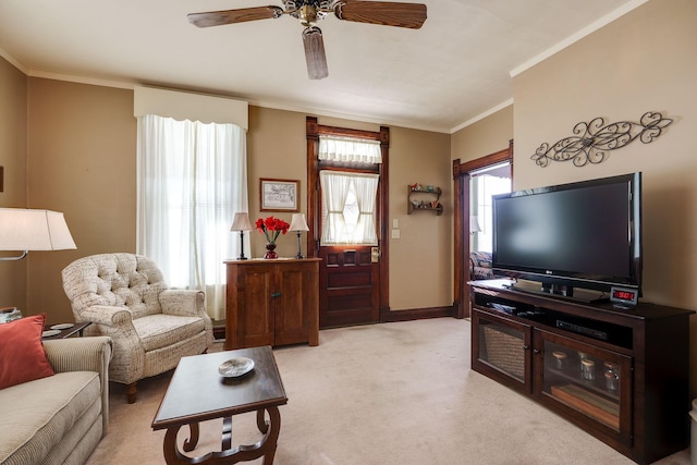 living area featuring ornamental molding, light carpet, baseboards, and a ceiling fan