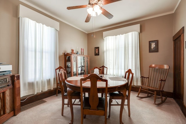 dining space with ornamental molding, a wealth of natural light, and light carpet