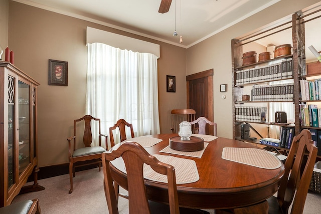 dining space featuring ornamental molding, carpet, and ceiling fan