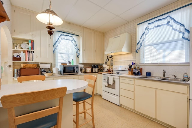 kitchen with stainless steel microwave, white electric range, pendant lighting, a sink, and exhaust hood