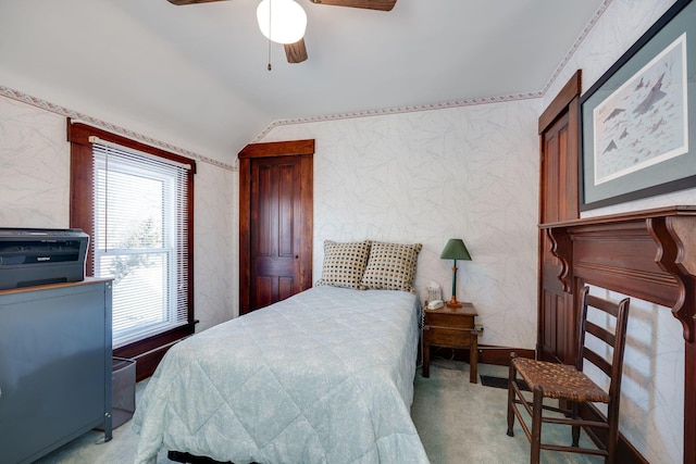 bedroom featuring light carpet, wallpapered walls, vaulted ceiling, and a ceiling fan