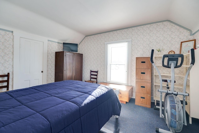 bedroom with vaulted ceiling, dark carpet, and wallpapered walls