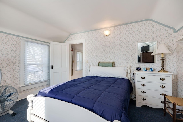 bedroom with lofted ceiling, wallpapered walls, and carpet floors