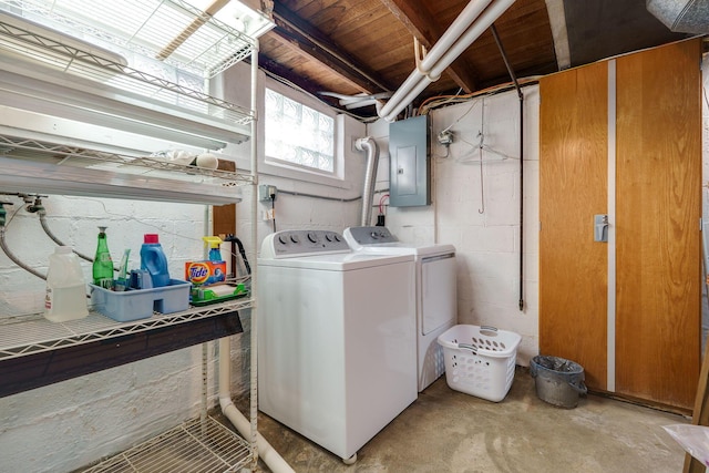 clothes washing area featuring laundry area, electric panel, and washing machine and clothes dryer