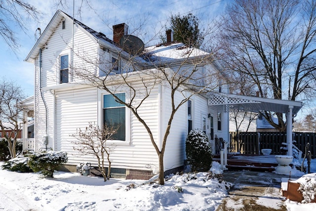 view of snow covered exterior featuring fence