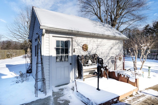 snow covered structure with fence