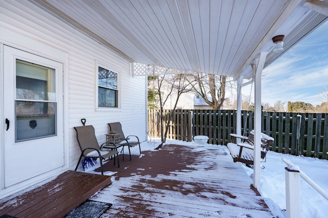 snow covered deck featuring fence