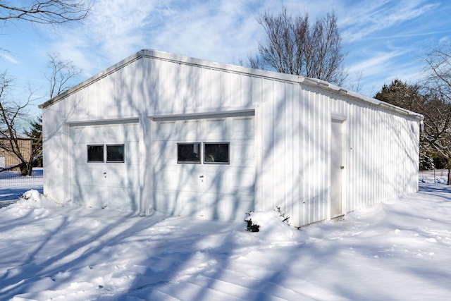 snow covered garage with a garage