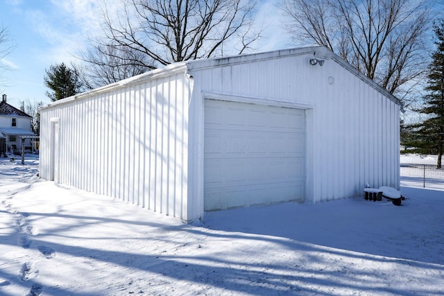 snow covered garage with a detached garage