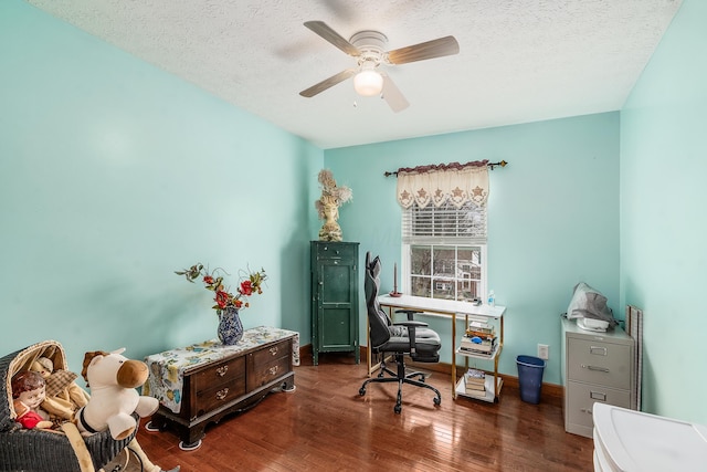 office space featuring baseboards, a textured ceiling, a ceiling fan, and dark wood-type flooring