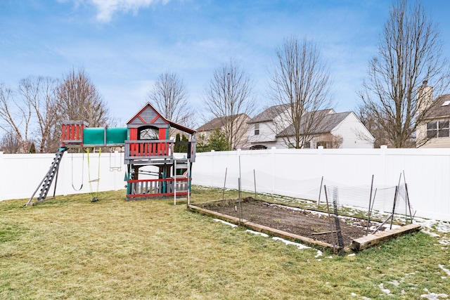 view of yard with a garden, a playground, and a fenced backyard