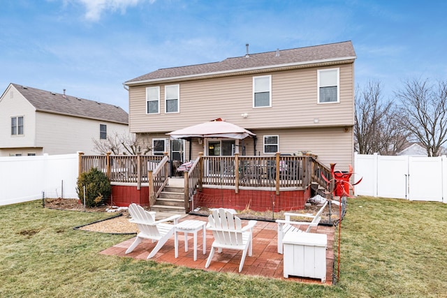 back of house with a fenced backyard, a lawn, and a deck