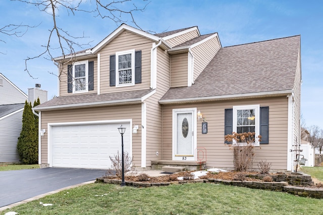 traditional home with driveway, an attached garage, a shingled roof, and a front yard