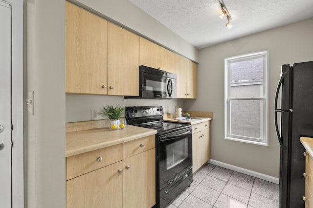 kitchen featuring black appliances, light brown cabinets, and light countertops