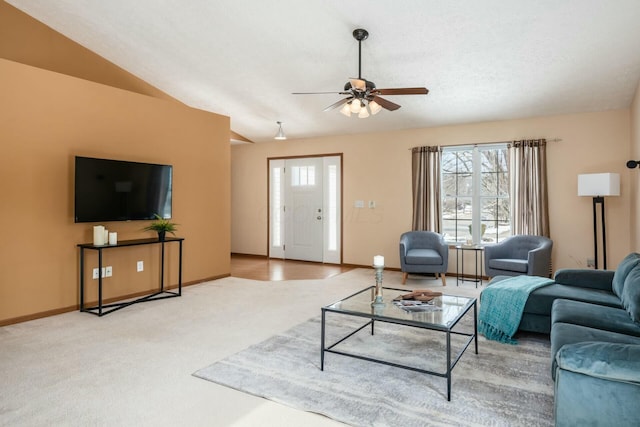 carpeted living area with vaulted ceiling, baseboards, and ceiling fan