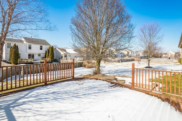 snow covered deck featuring a residential view