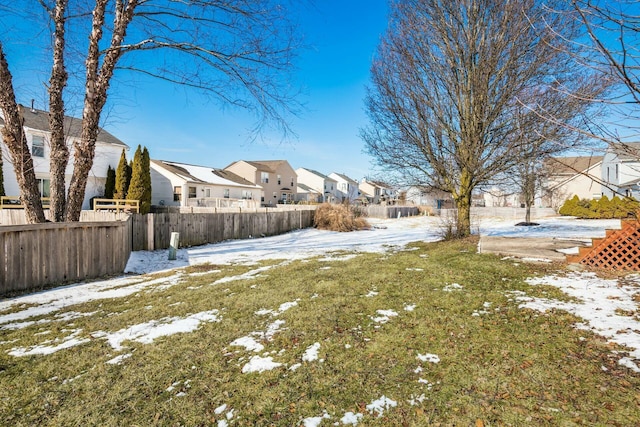 yard covered in snow featuring a residential view and fence