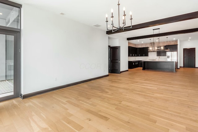 unfurnished living room featuring visible vents, baseboards, beamed ceiling, light wood-type flooring, and a chandelier