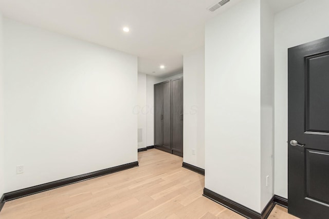 hallway featuring light wood-style flooring, recessed lighting, visible vents, and baseboards