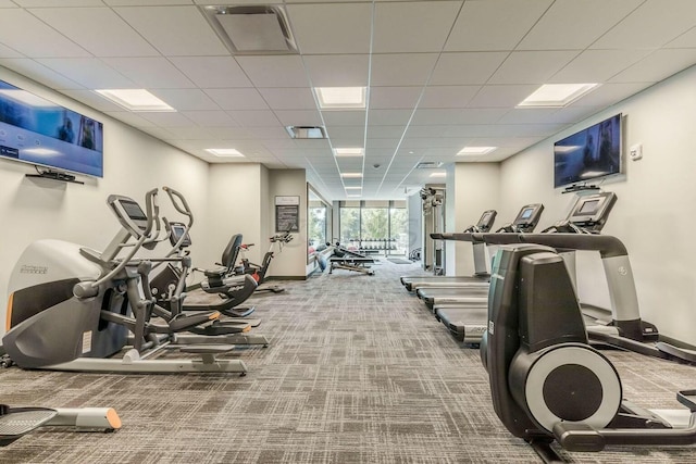 gym with baseboards, visible vents, a drop ceiling, and carpet flooring