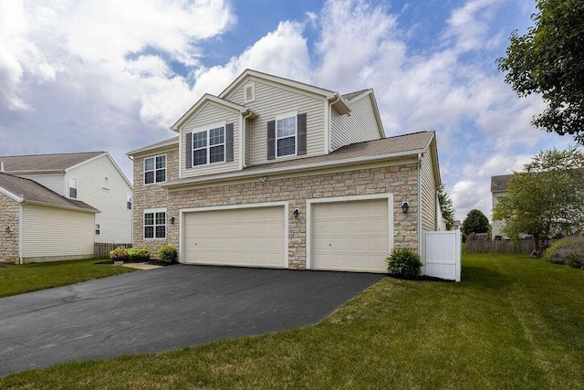 traditional home featuring a garage, driveway, stone siding, and a front yard