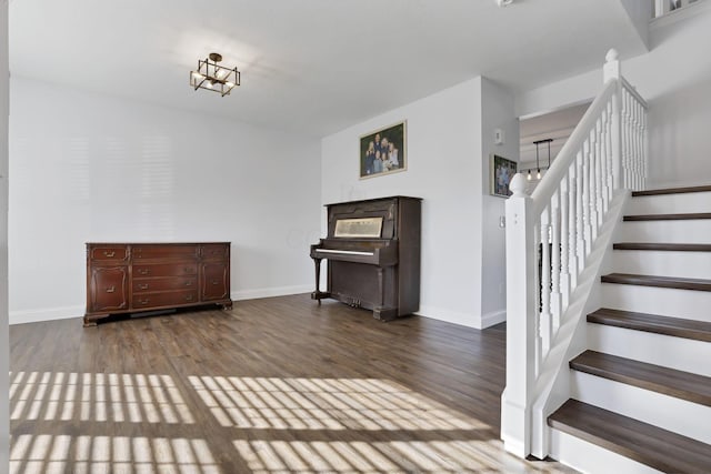 interior space featuring dark wood-style flooring, stairway, and baseboards