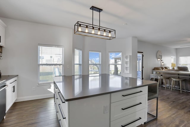 kitchen with dark countertops, white cabinetry, open floor plan, and dark wood-type flooring