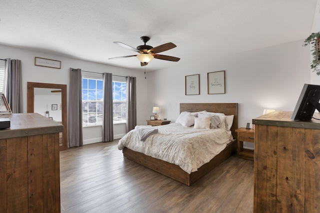 bedroom with a ceiling fan, dark wood finished floors, and baseboards