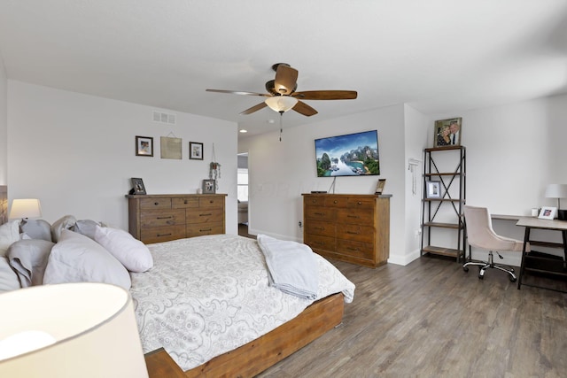 bedroom featuring a ceiling fan, baseboards, visible vents, and wood finished floors