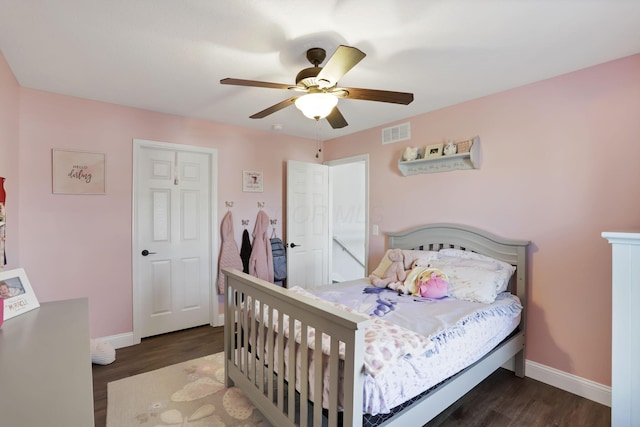 bedroom featuring a ceiling fan, visible vents, baseboards, and wood finished floors