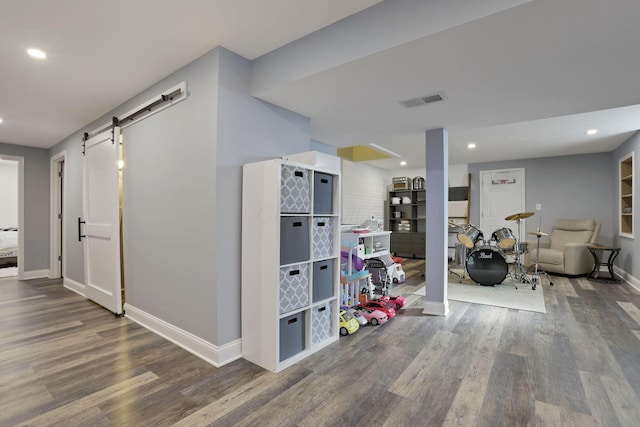 interior space featuring recessed lighting, wood finished floors, and a barn door