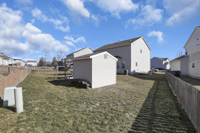 view of side of property with an outbuilding, a yard, a shed, and a fenced backyard