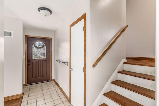 foyer featuring light tile patterned floors, stairway, visible vents, and baseboards