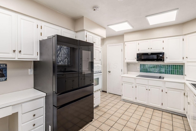 kitchen with black appliances, light countertops, and white cabinets